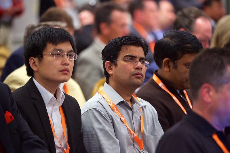 Conference attendees listening to speakers at a telecom industry event